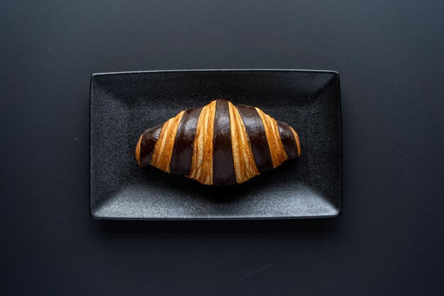 Croissant and a cup of tea on a neutral background selective focus