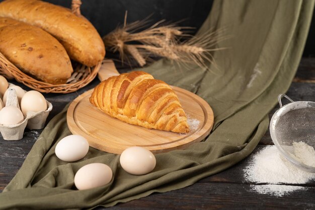 Foto croissant en brood op een rustieke houten achtergrond vers gebakken brood op tafel brood