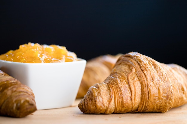 Croissant met jam op een donkere achtergrond