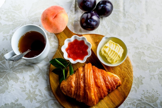 Croissant met thee en jam als ontbijt