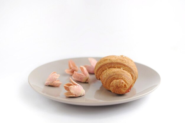 Croissant met versierde bloemen in de horizontale weergave van de grijze plaat