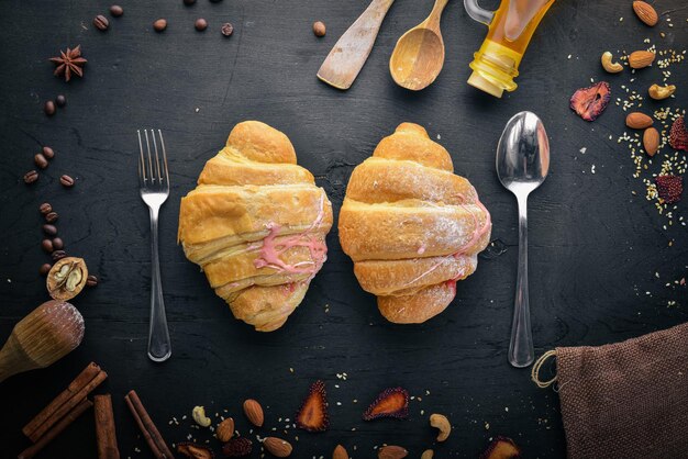 Croissant met yoghurt Gebakdeeg Op een zwarte houten ondergrond Vrije ruimte voor tekst Bovenaanzicht