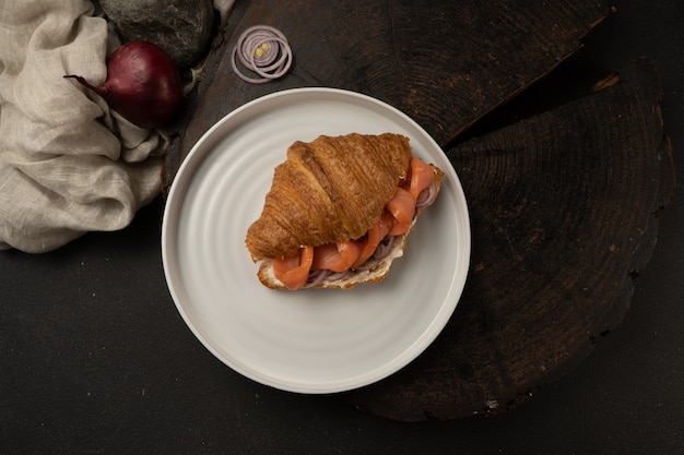 Croissant met zalm, ricotta, kappertjes en ingelegde uitjes. Licht ontbijt met gebak, vis en groenten