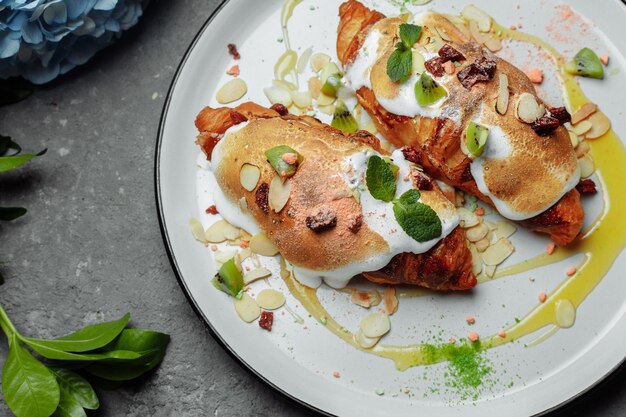 Croissant met zoete room en amandelen op een bord Heerlijk en gezond ontbijt