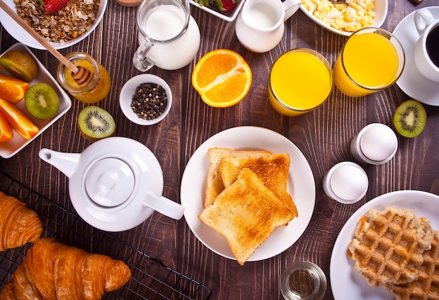 Croissant, Muesli, toasts, fruits, eggs, waffles and cup of coffee