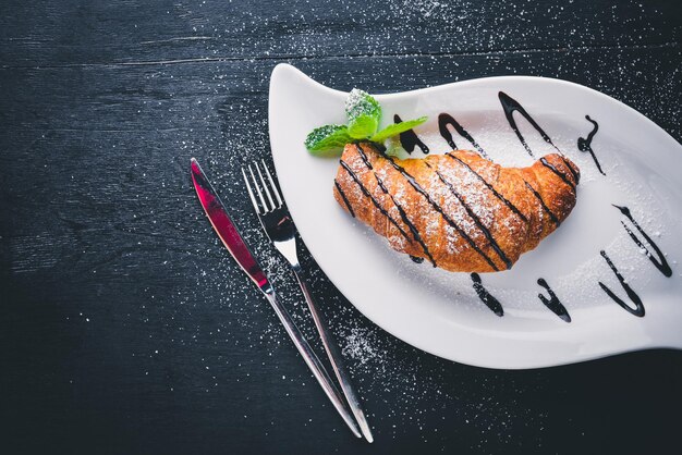 Croissant. Op een houten achtergrond. Bovenaanzicht. Vrije ruimte voor uw tekst.