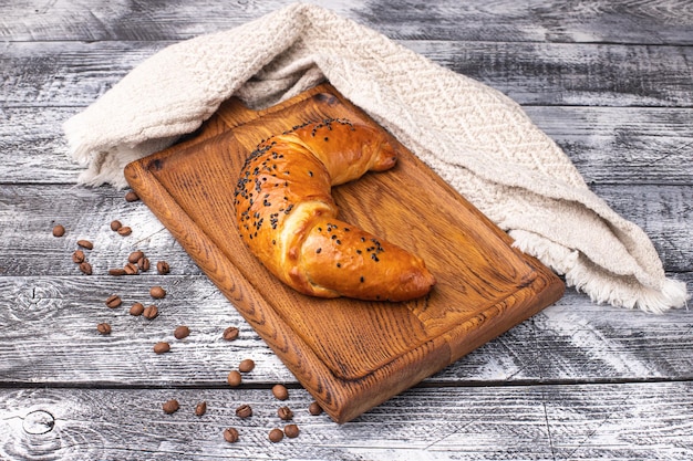 Croissant op een witte houten achtergrond houten plaat