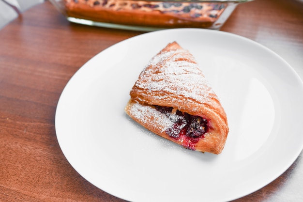 Croissant op een witte plaat. Croissant op witte plaat, bovenaanzicht. Zweet gebakken dessert in een dis.