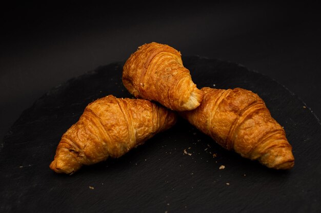 Croissant op zwarte achtergrond gedetailleerde voedselschot