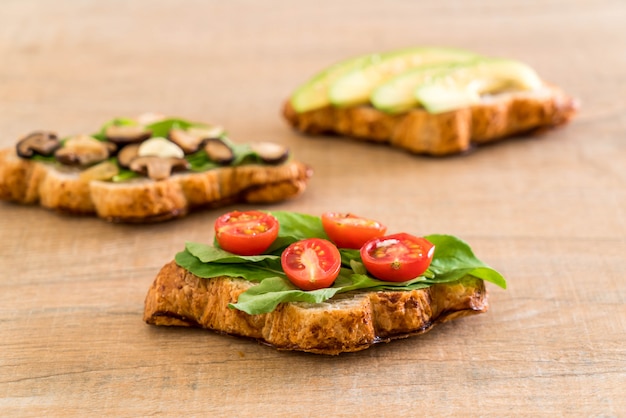 croissant sandwich with avocado, tomatoes and mushroom