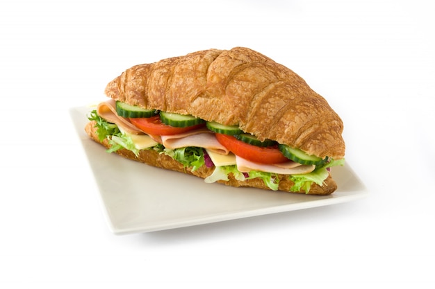 Croissant sandwich with cheese, ham and vegetables