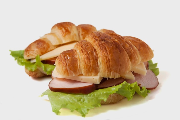 Croissant sandwich with ham and cheese on a white plate