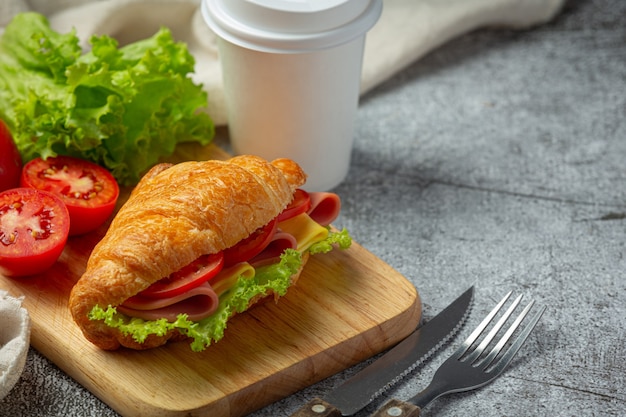 Croissant sandwiches on dark wooden surface