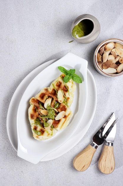 Croissant Waffle or Croffle with greentea sauce and chopped almond easy making for breakfast