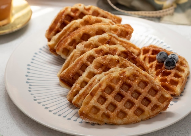 Croissant waffle or its famous names croffle on white plate\
with white background.