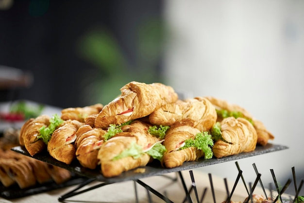 croissant with bacon and salad on a black stone background. Top view. catering