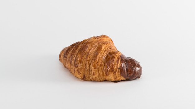 Foto croissant con ripieno di cioccolato su fondo bianco