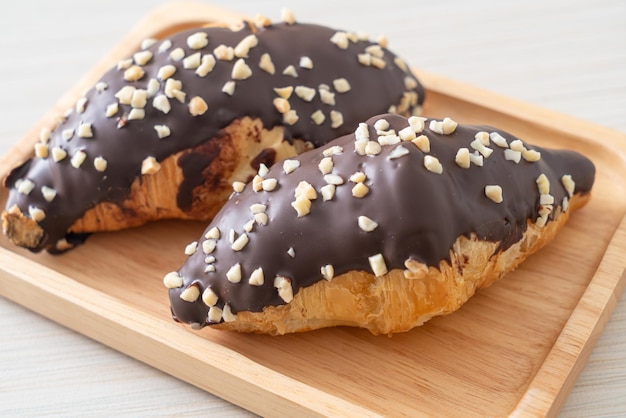 croissant with chocolate and nutty on wood plate