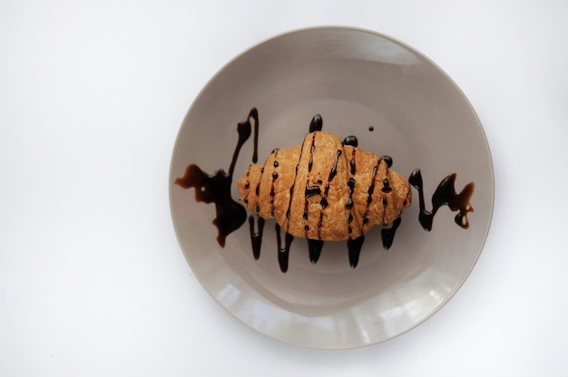 Croissant with covered chocolate on the grey plate top view