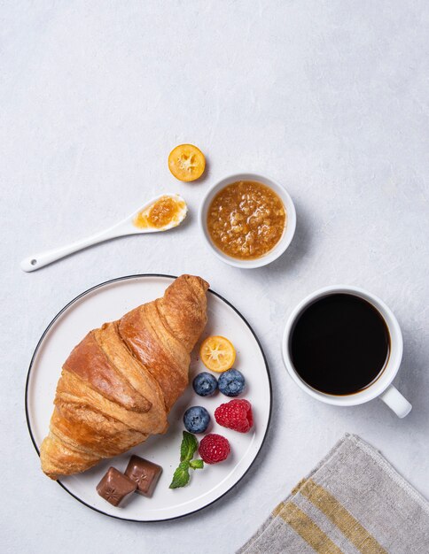 コーヒーとベリーのカップとクロワッサン