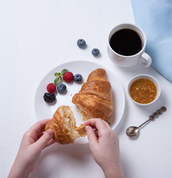 Croissant with a cup of coffee and berries