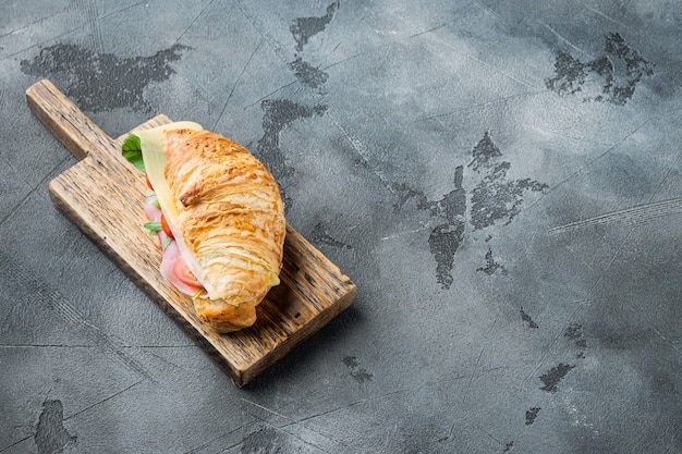 Croissant with ham set, on gray stone background, with copy space for text