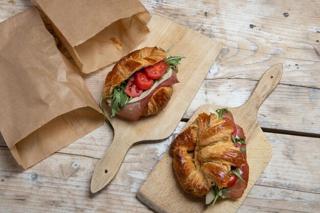 Photo croissant with jamon, cheese, salad and tomatoes for breakfast