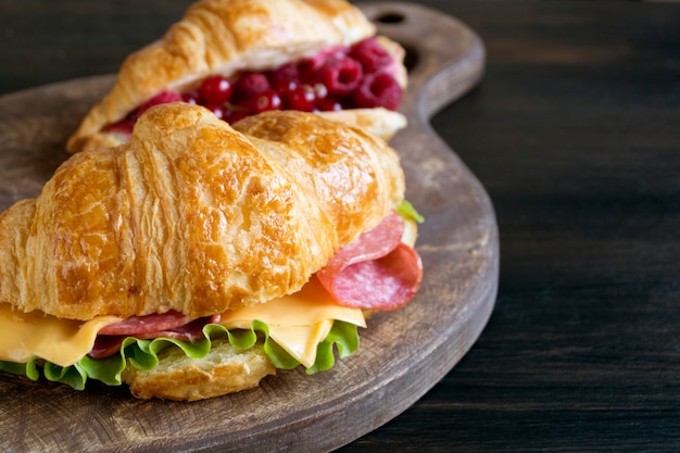 Croissant with sausage cheese and herbs. on dark background