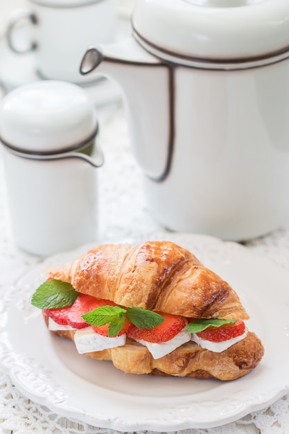 Croissant with strawberries, brie cheeseand mint