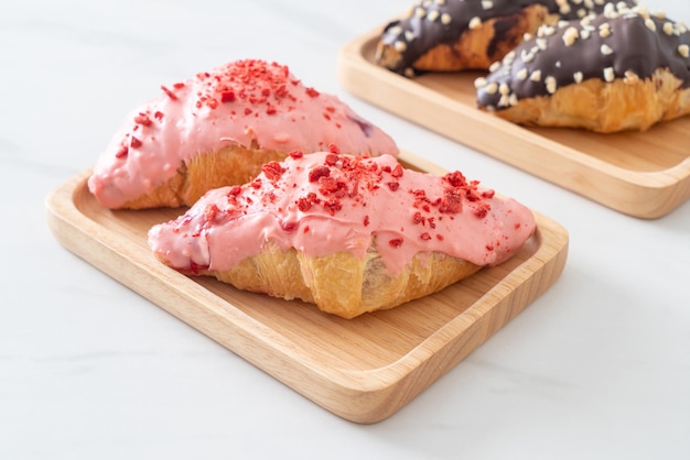 croissant with strawberry chocolate sauce on wood plate