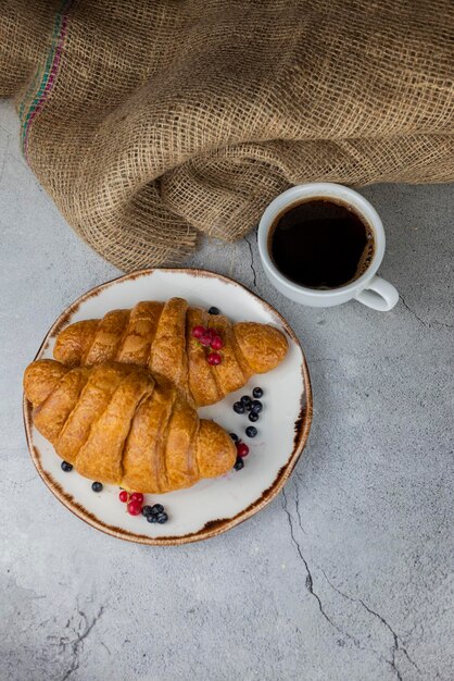 朝食用のカップにコーヒーと生地のクロワッサンおいしいvipechka