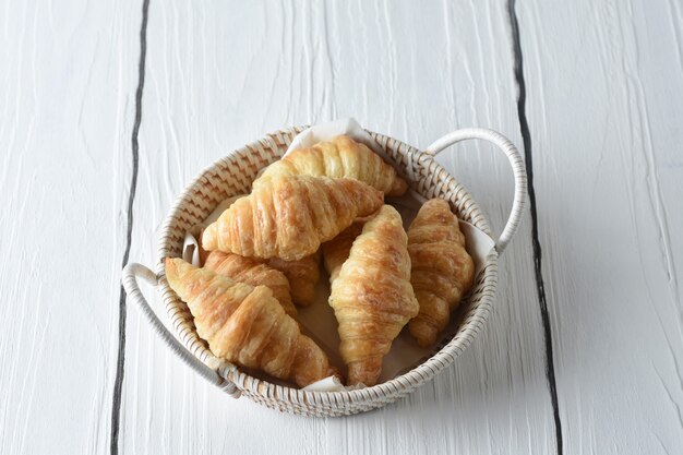 クロワッサン朝食用のジャムの小さな瓶が付いているトレイの焼きたてのクロワッサン