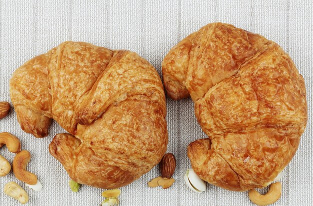 Croissants and almonds on a tablecloth.