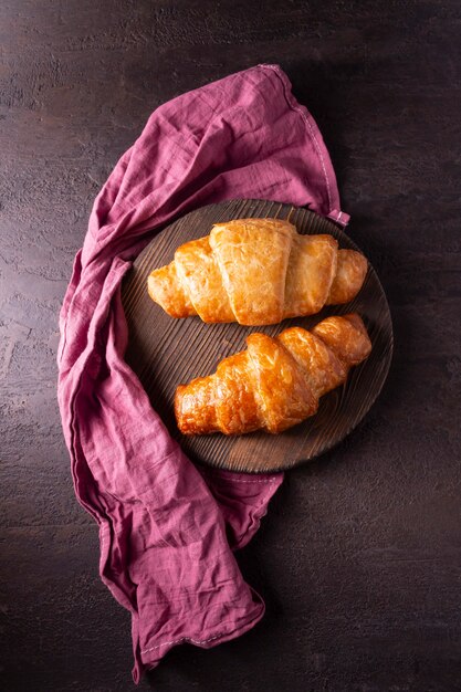 Croissants on a black plate and a red napkin dark photo