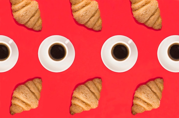 Croissants and coffee cups on the red background Pattern Flat lay