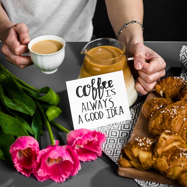 Croissants cup of coffee and a bouquet of tulips