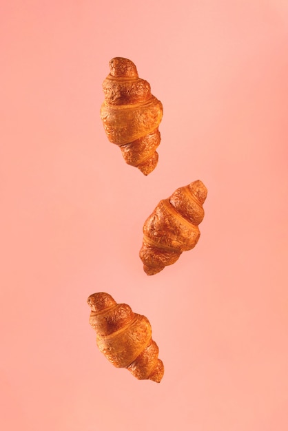 Croissants die op roze vliegen. Levitatie scene.