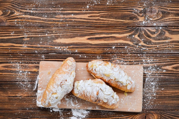 Croissants met amandelen en thee op een houten tafel