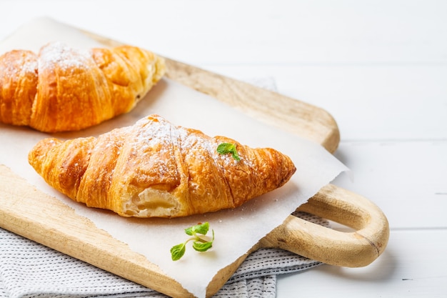 Croissants met bessenjam op een witte houten achtergrond