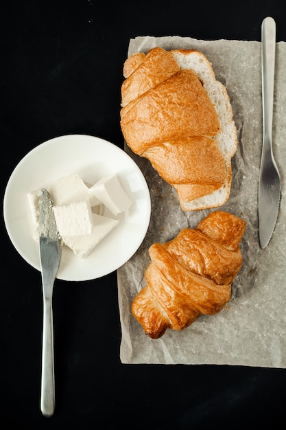 Croissants met boter op een zwarte tafel