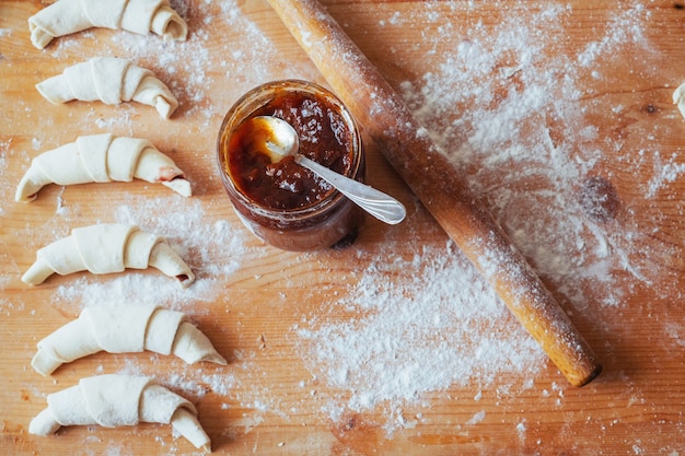 Croissants met jam op een houten bord