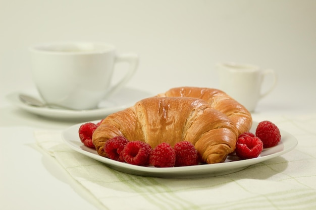 Croissants met koffie en heerlijke verse frambozen