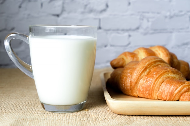 Croissants and milk on table.