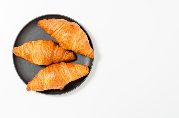 Croissants op de plaat op zwarte achtergrond Bovenaanzicht