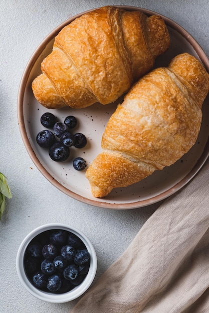 Foto croissants op een bord met bosbessen