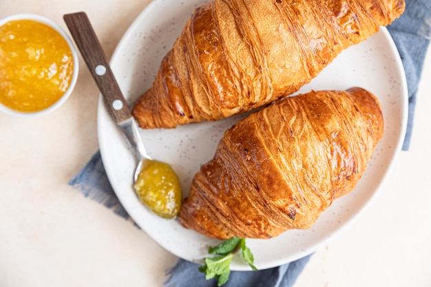 Croissants op keramische plaat met jam lichte betonnen achtergrond