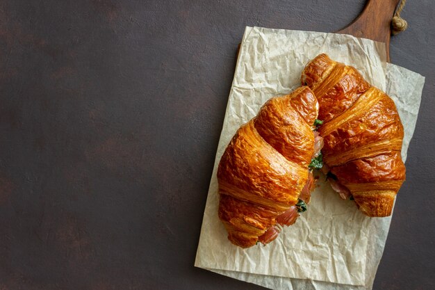 Croissants sandwiches with prosciutto, basil and white cheese. French cuisine. Breakfast.