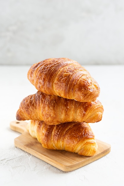 Croissants in a stack on a wooden board isolated