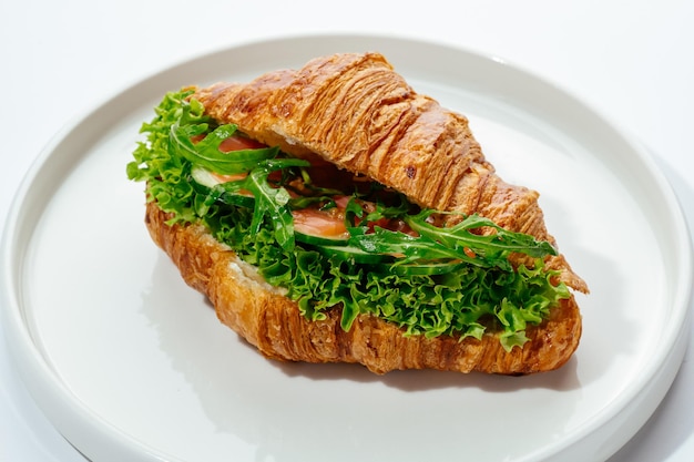 白い背景にハムと野菜でめ込まれたクロワッサン