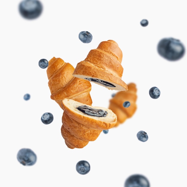 Croissant ai mirtilli che levitano su fondo bianco